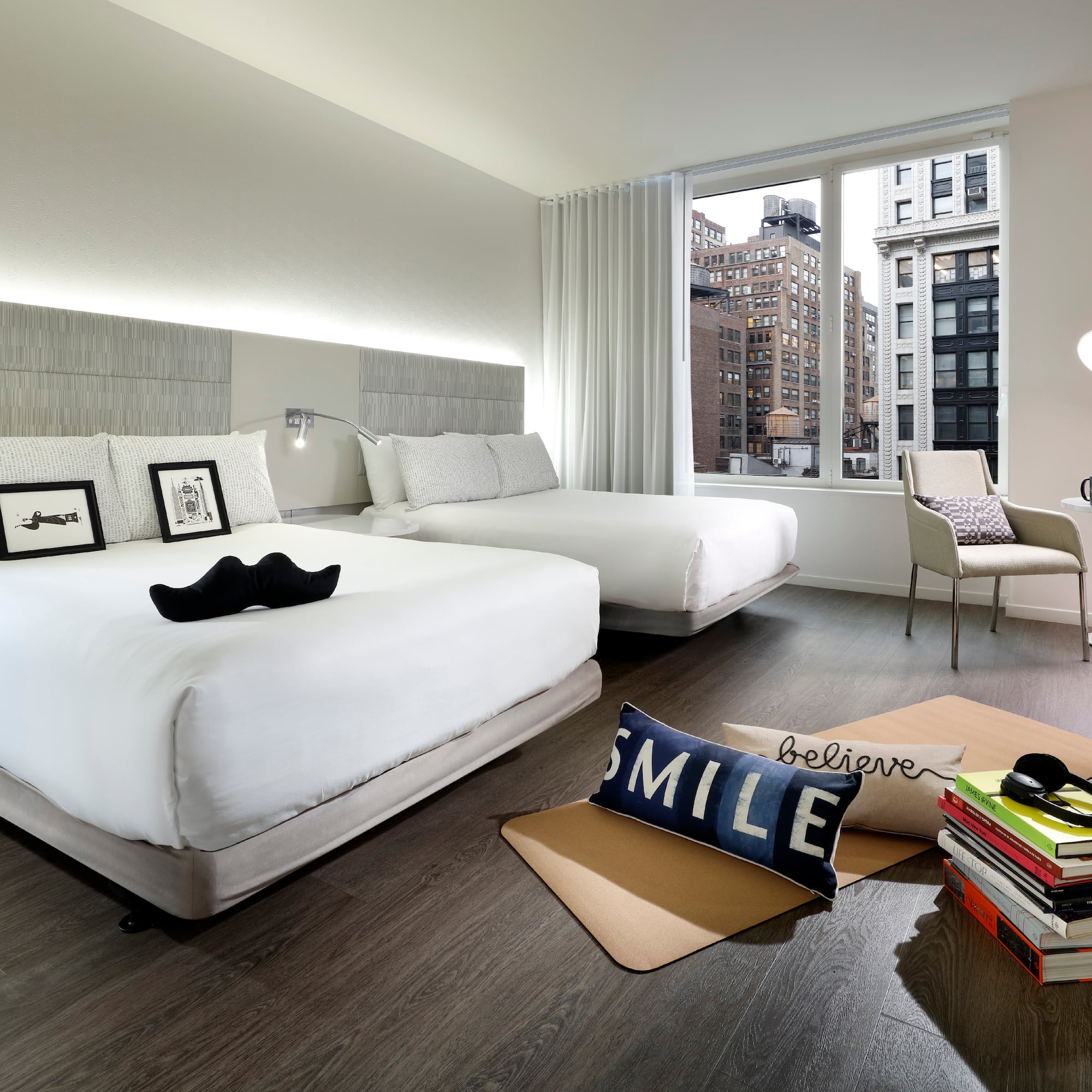 a room with two beds and a chair