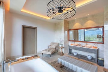 a bathroom with a large chandelier and a tub