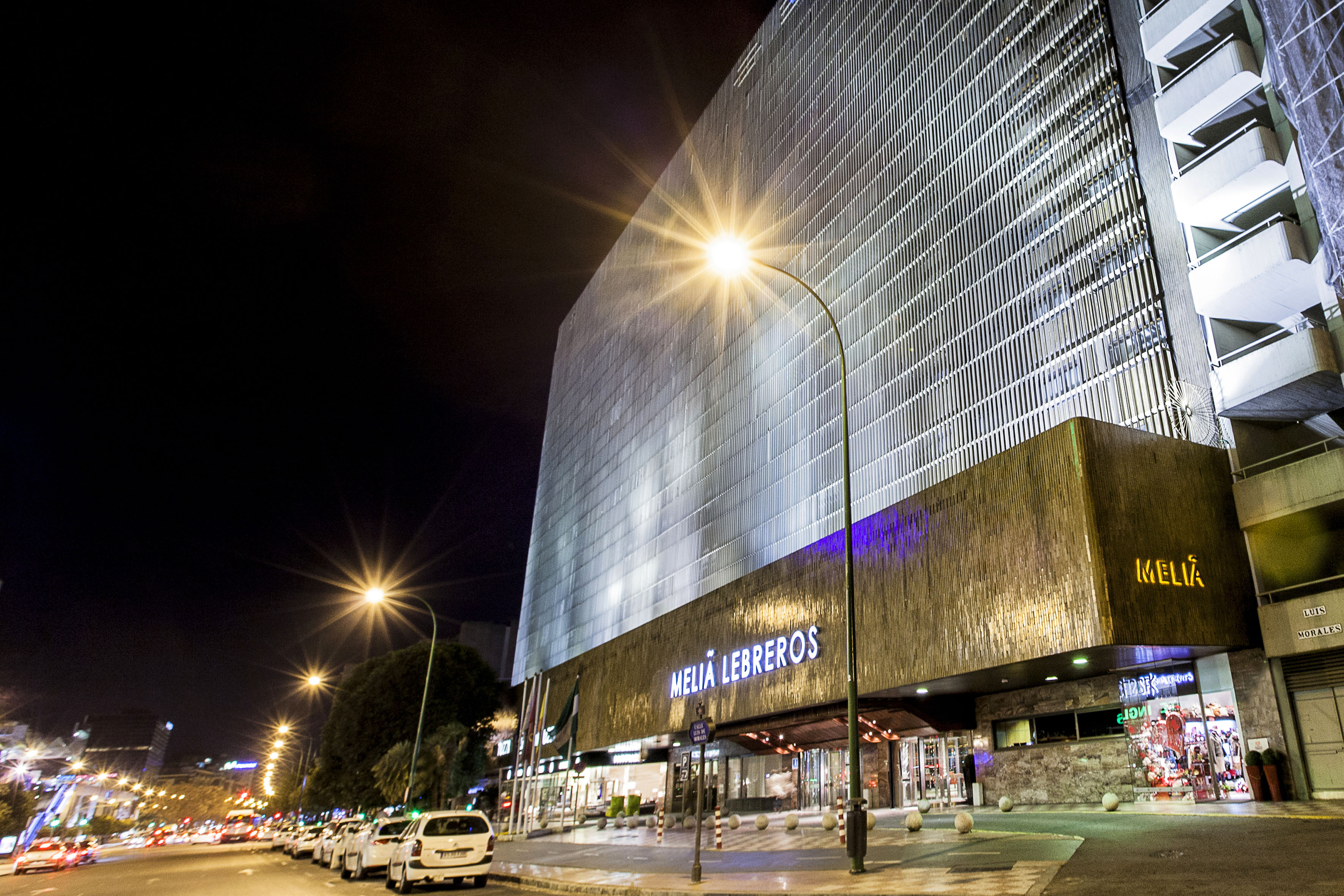 Meliá Lebreros hotel exterior at night, modern building facade, streetlights.