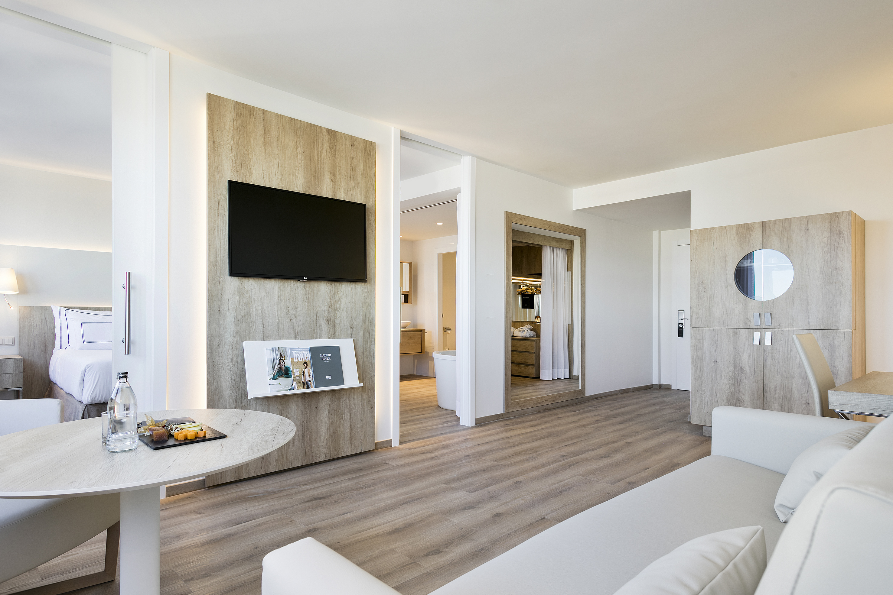 Modern hotel suite with living area, bedroom, and contemporary design.