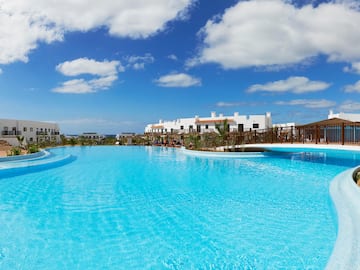 a pool with a bridge and buildings in the background