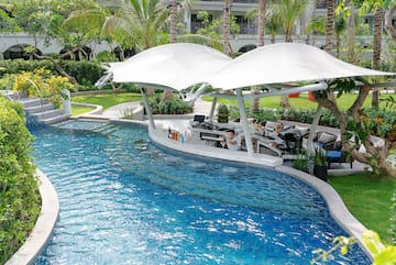 a pool with a bar and a man sitting at it