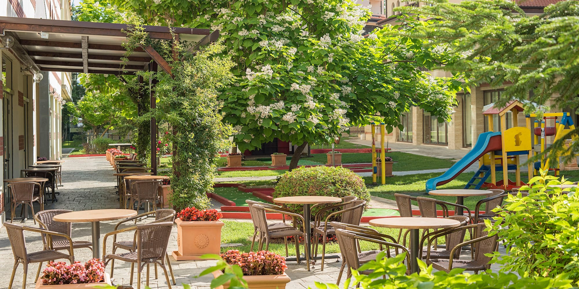 a playground with tables and chairs and a slide