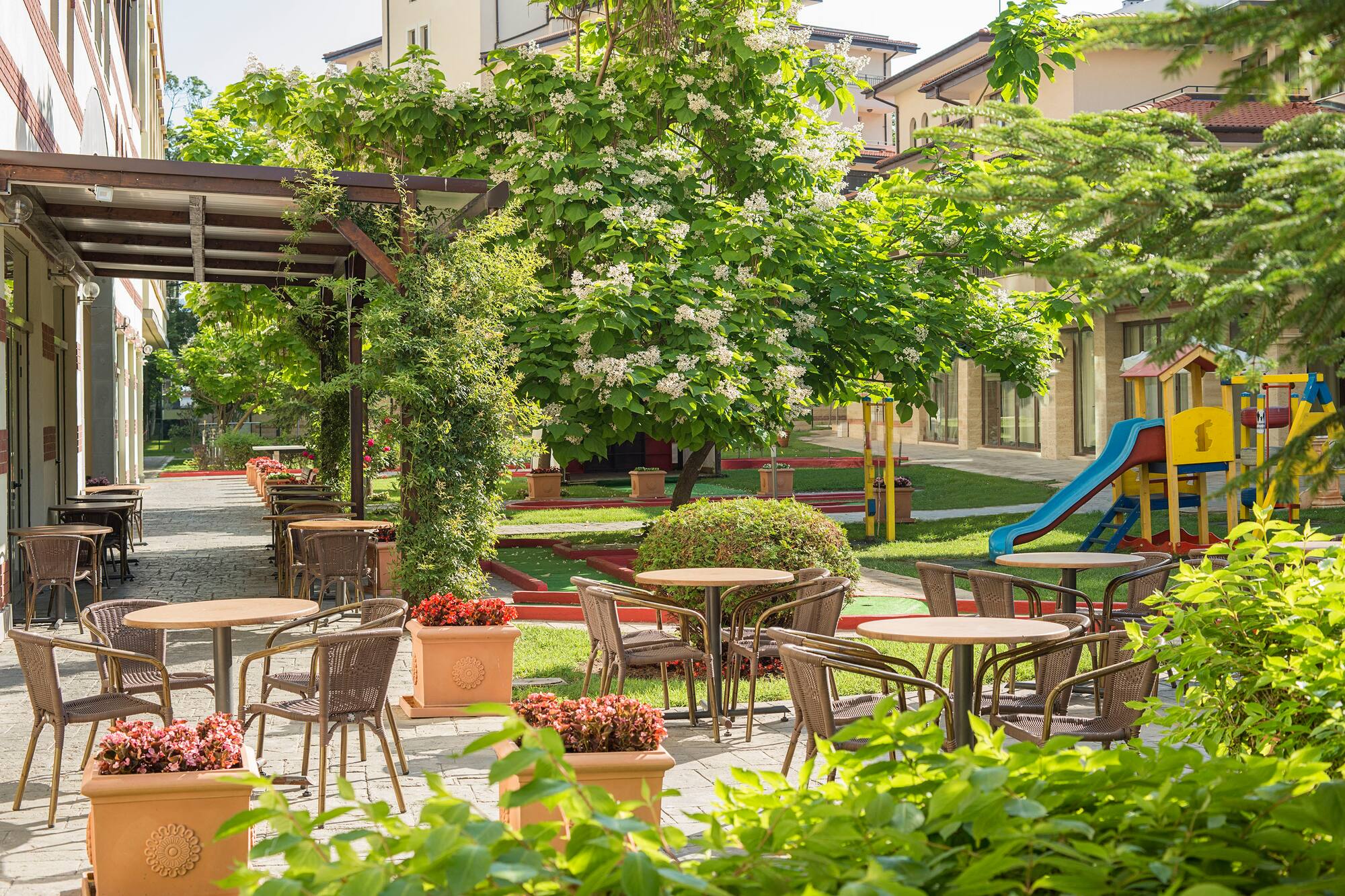 a playground with tables and chairs and a slide