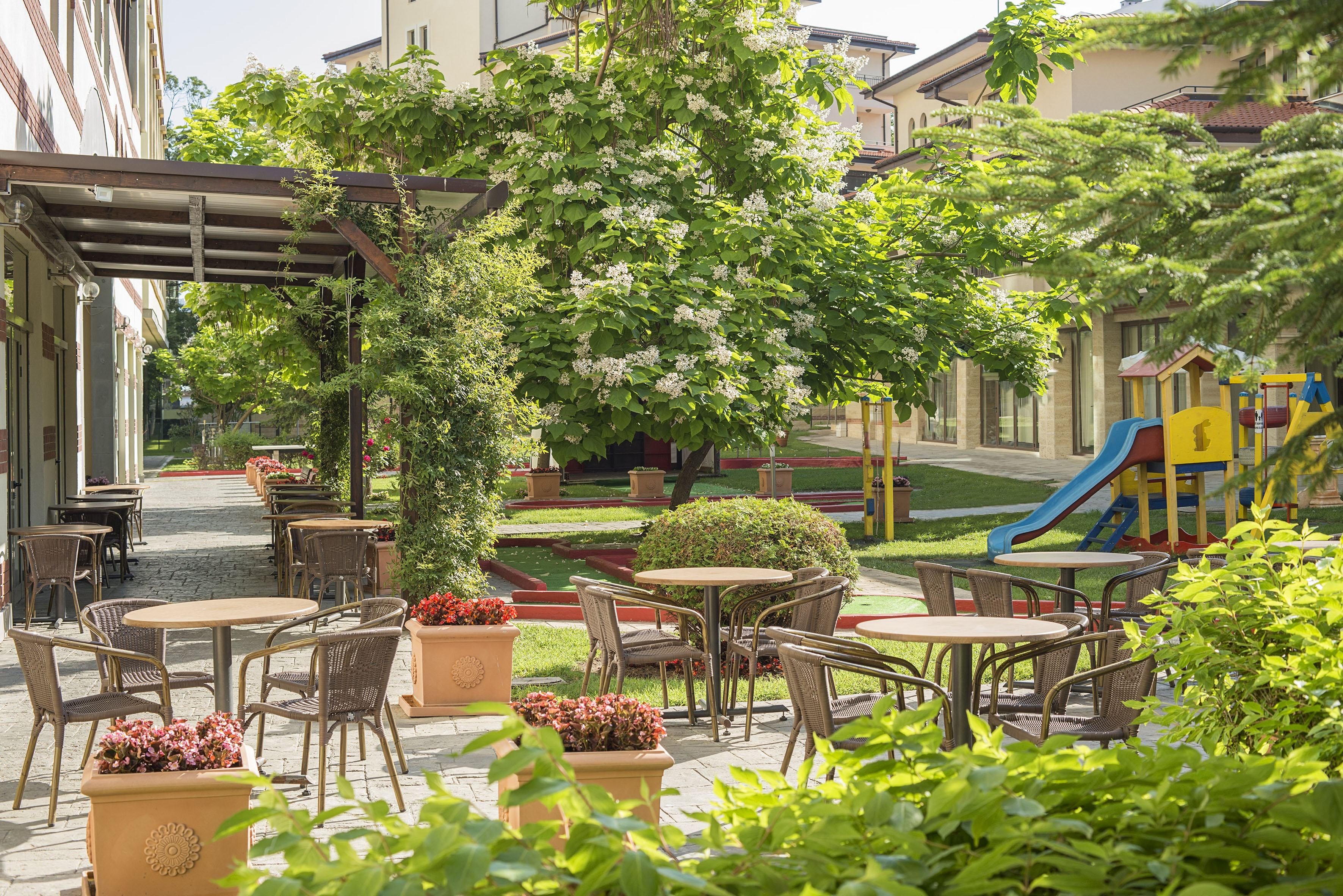 a playground with tables and chairs and a slide
