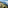 Terraced Mediterranean coast with a winding road, green hills, and blue sea.