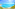 a blue water with a beach and buildings in the background