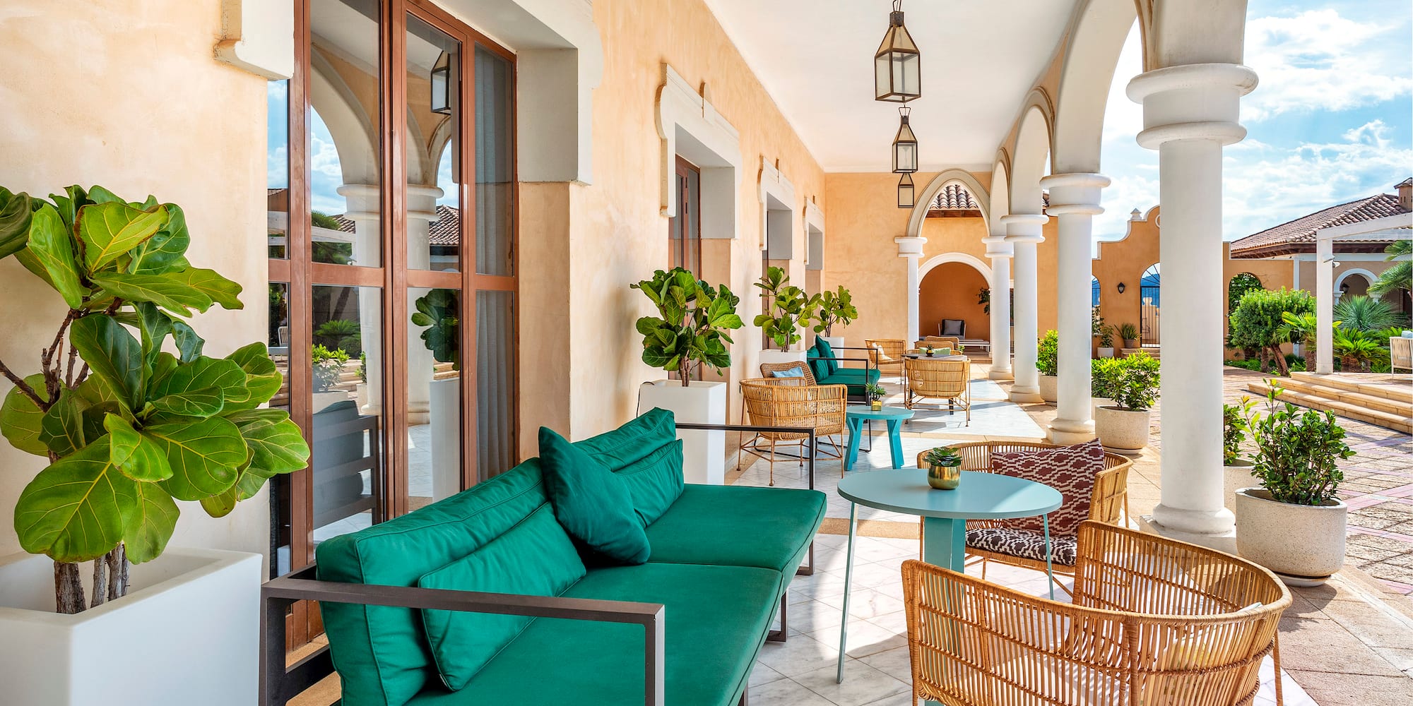 a patio with a green couch and chairs