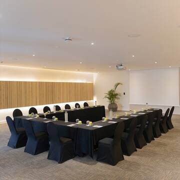 a room with long black tablecloths and chairs