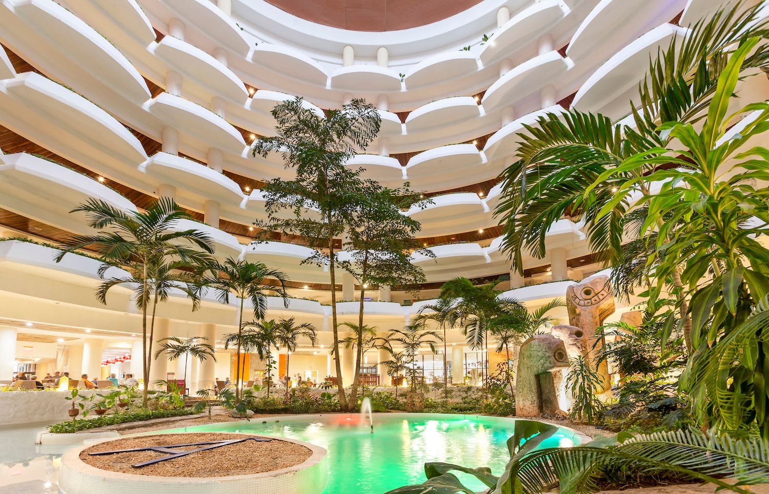 a pool inside a building with trees and plants
