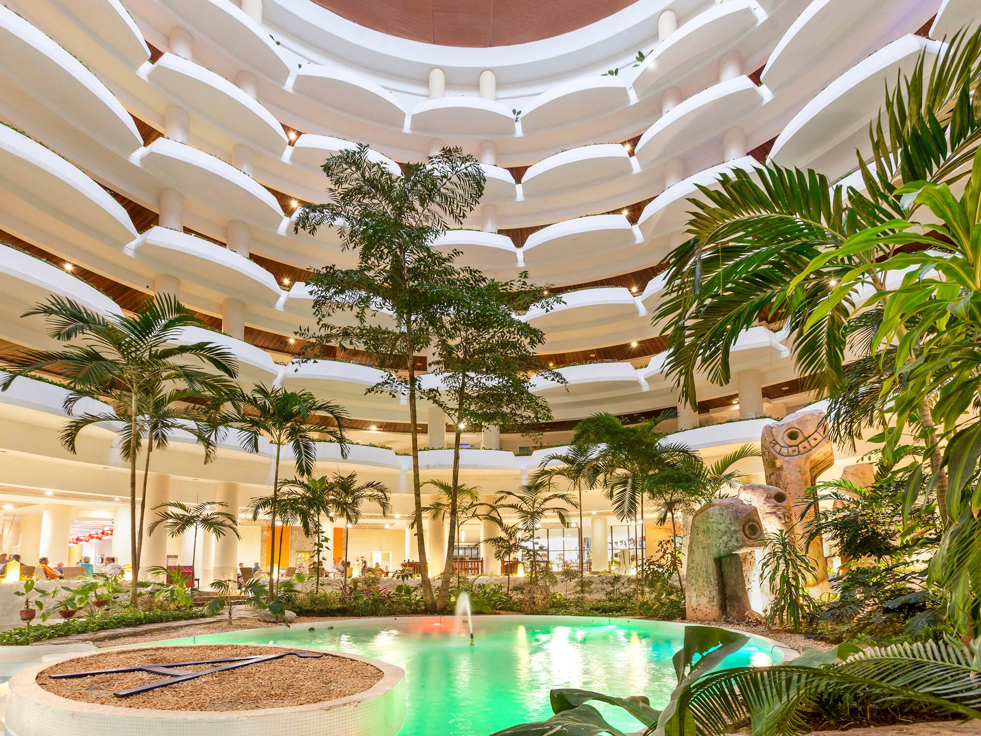 a pool inside a building with trees and plants