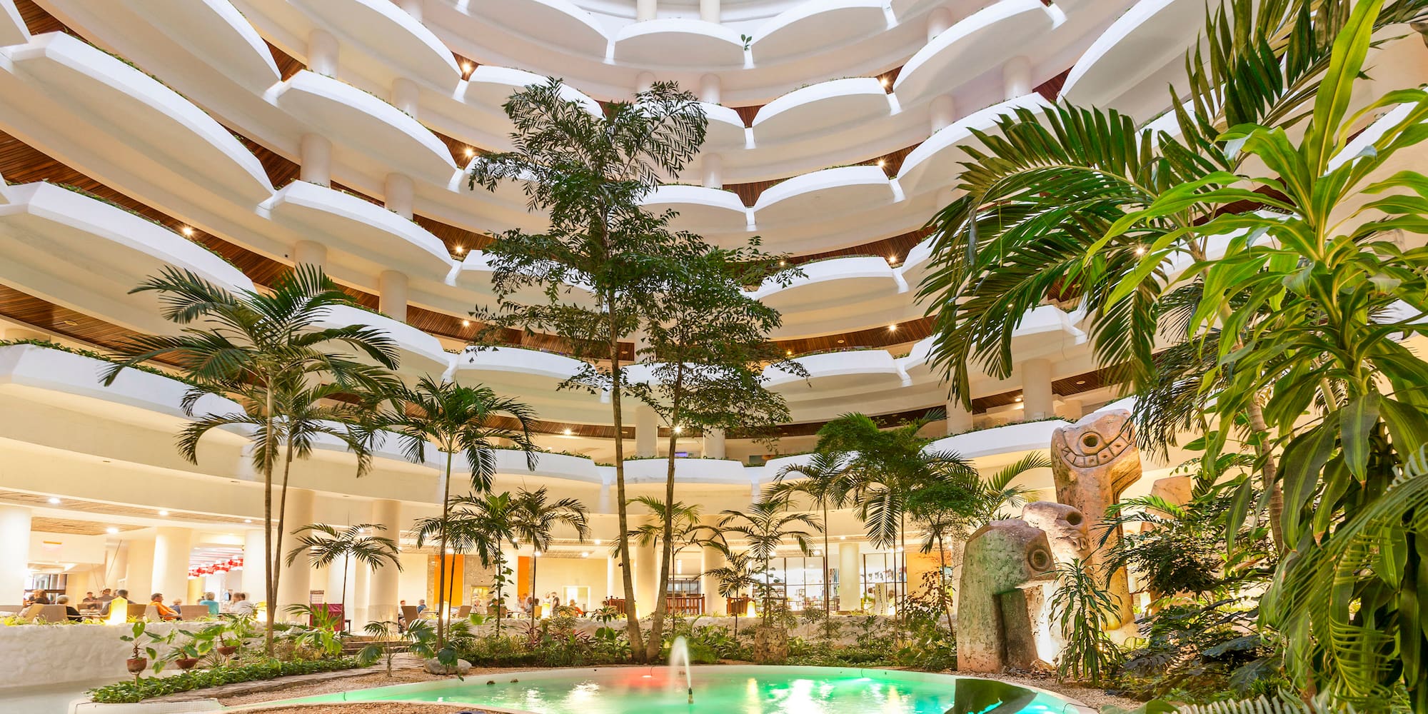 a pool inside a building with trees and plants