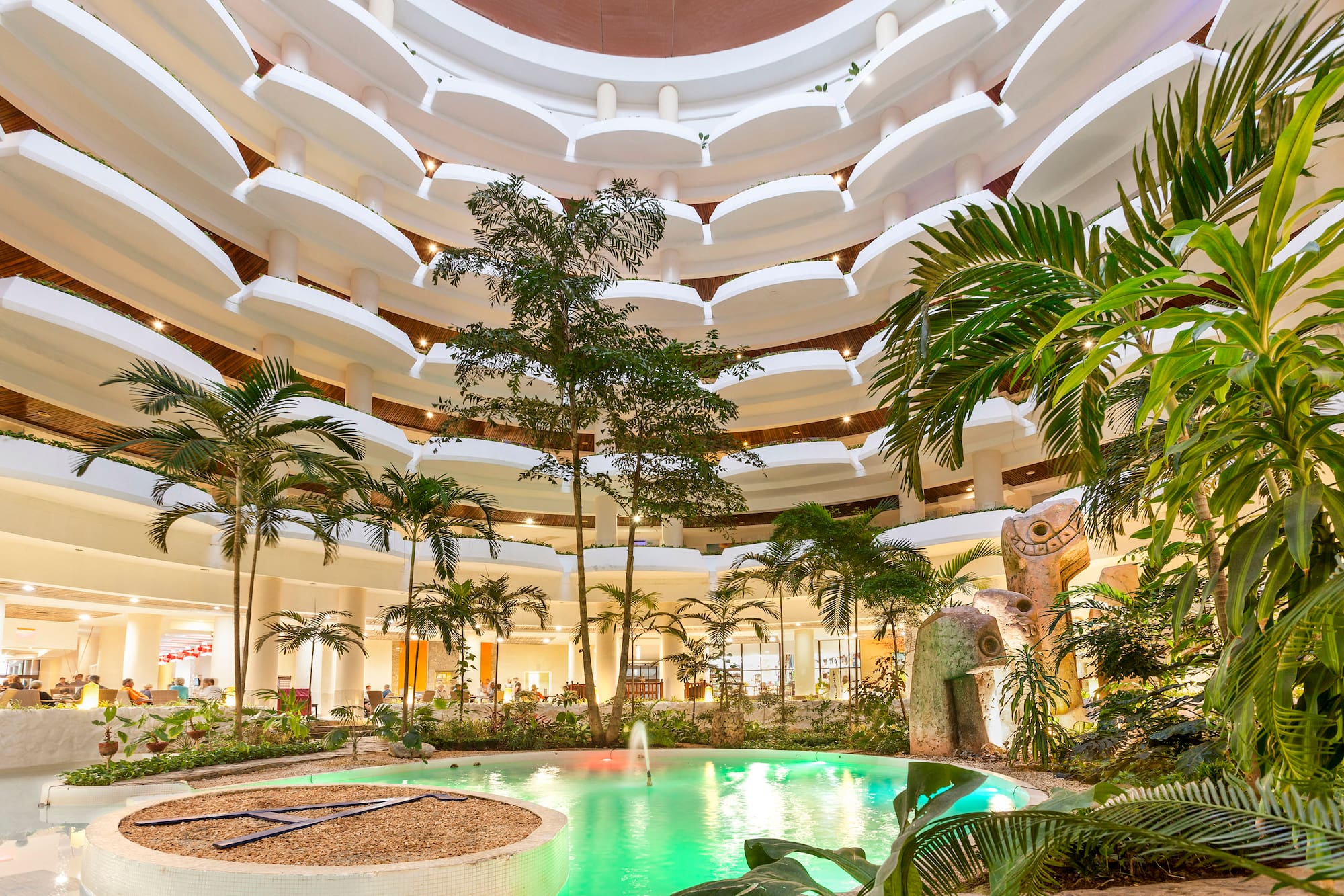 a pool inside a building with trees and plants