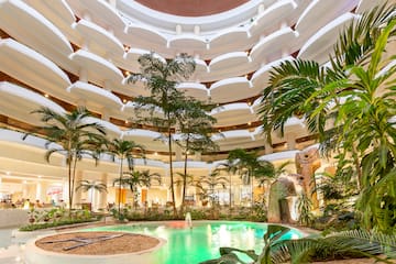 a pool inside a building with trees and plants