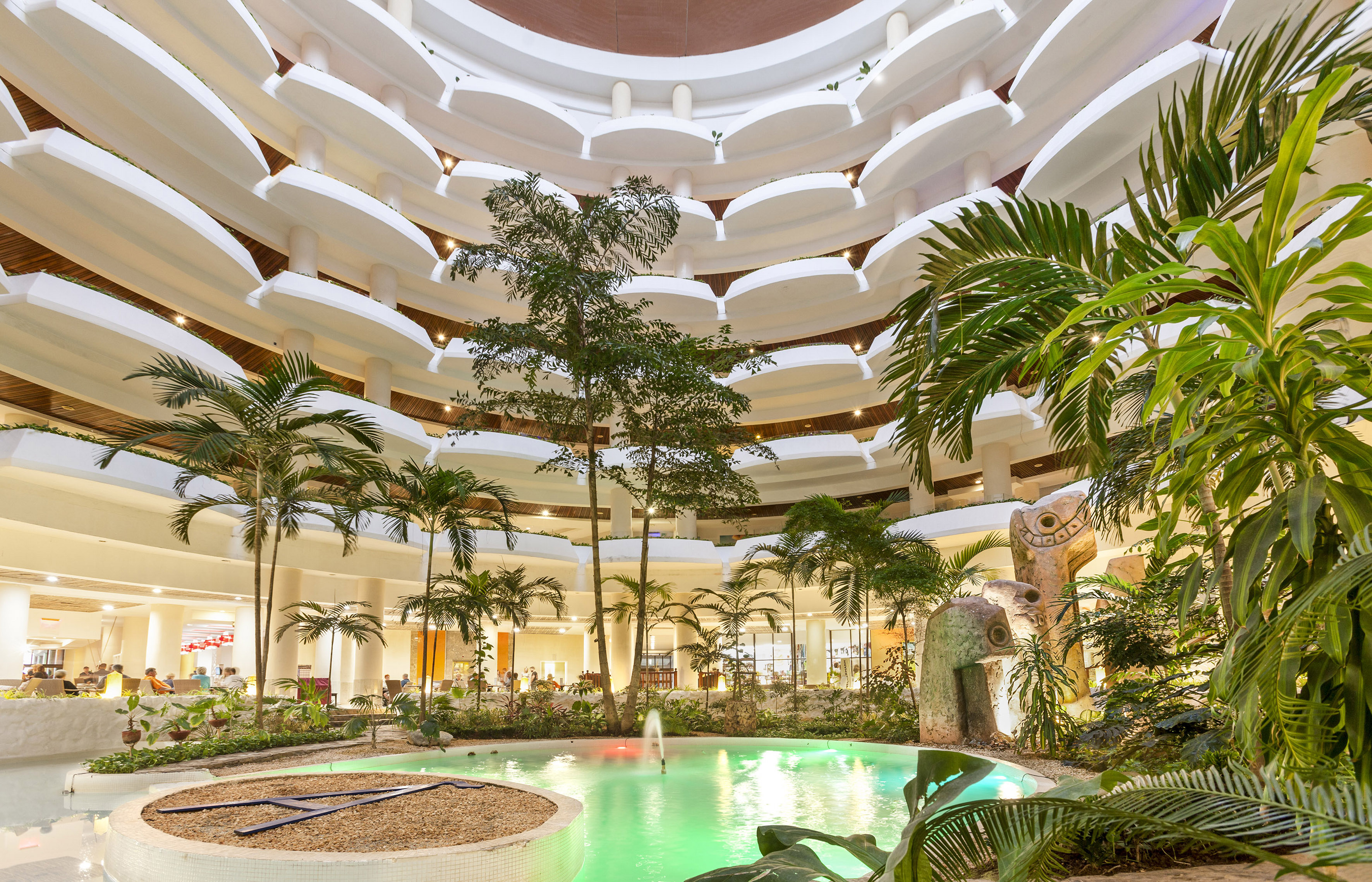 a pool inside a building with trees and plants