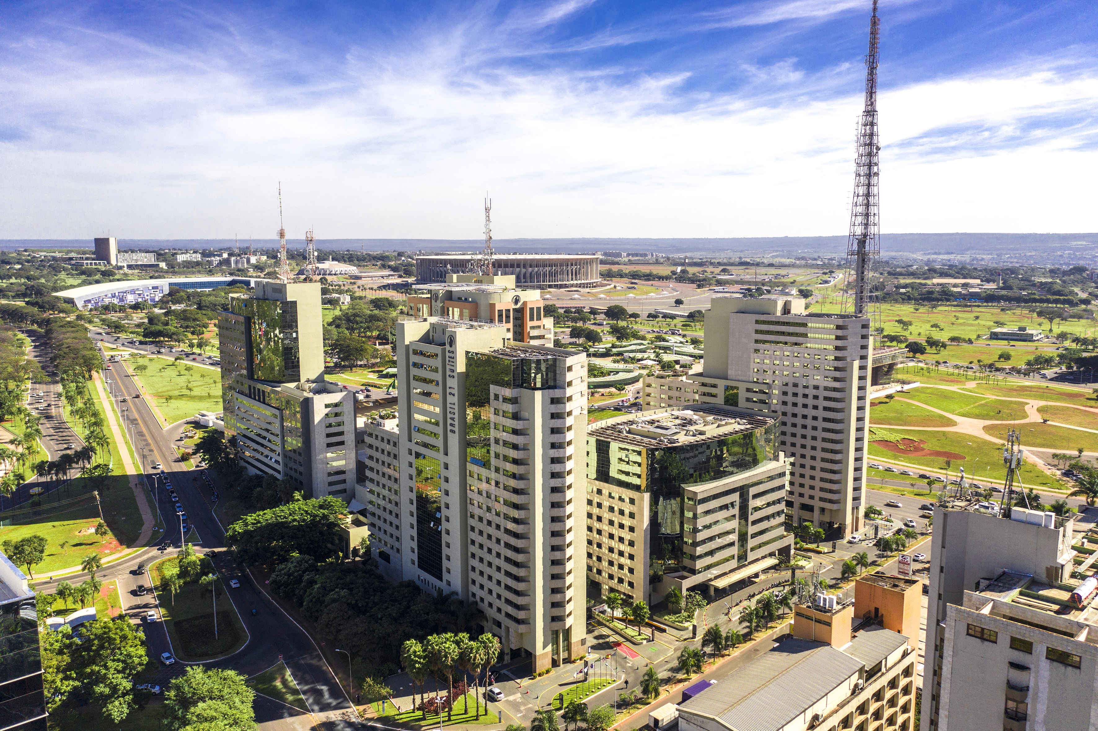 Brasília city with modern buildings, Nacional Stadium, and green urban landscape.