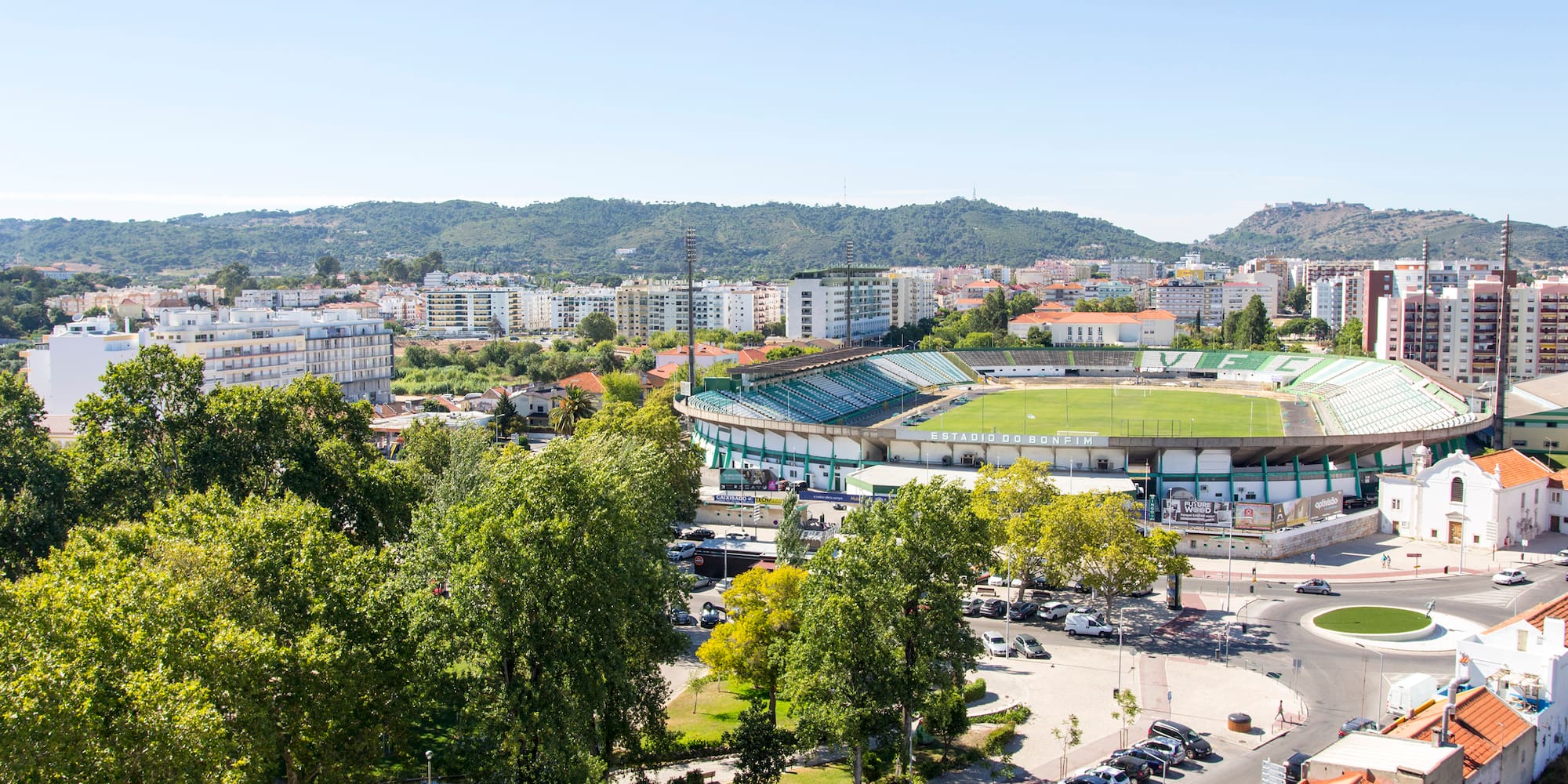 a stadium with trees and buildings in the background