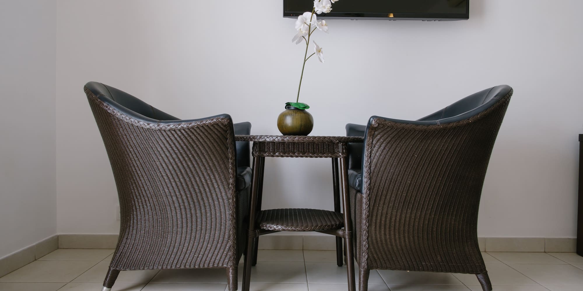 a table with chairs and a vase of flowers