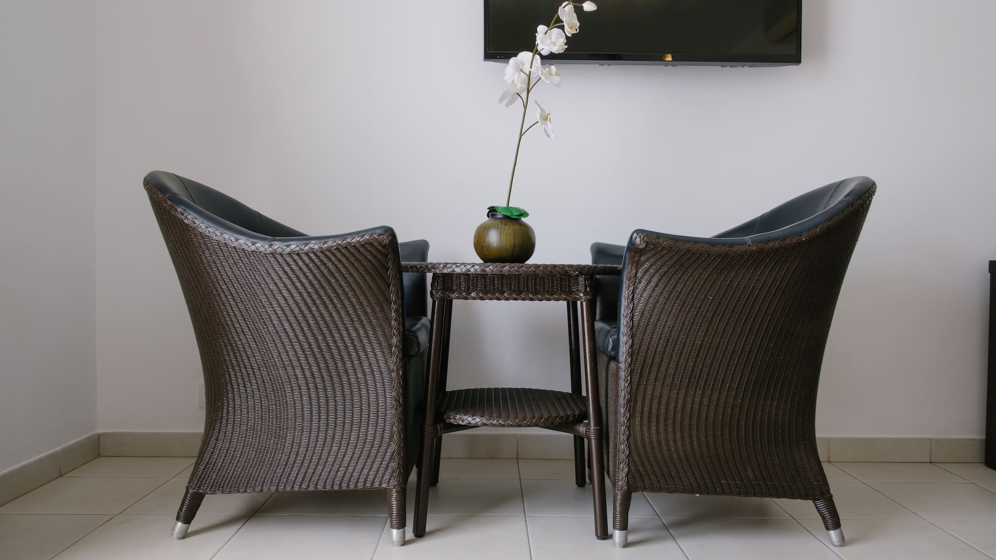 a table with chairs and a vase of flowers