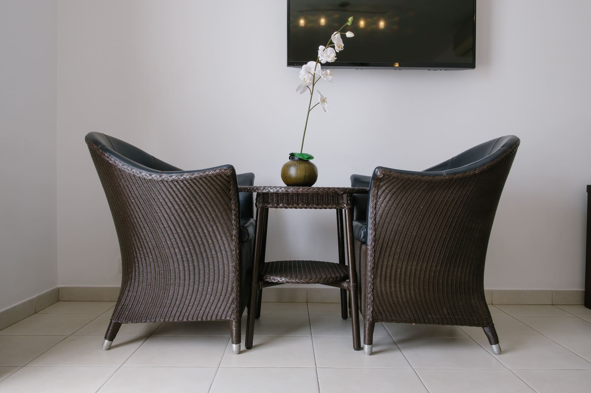 a table with chairs and a vase of flowers