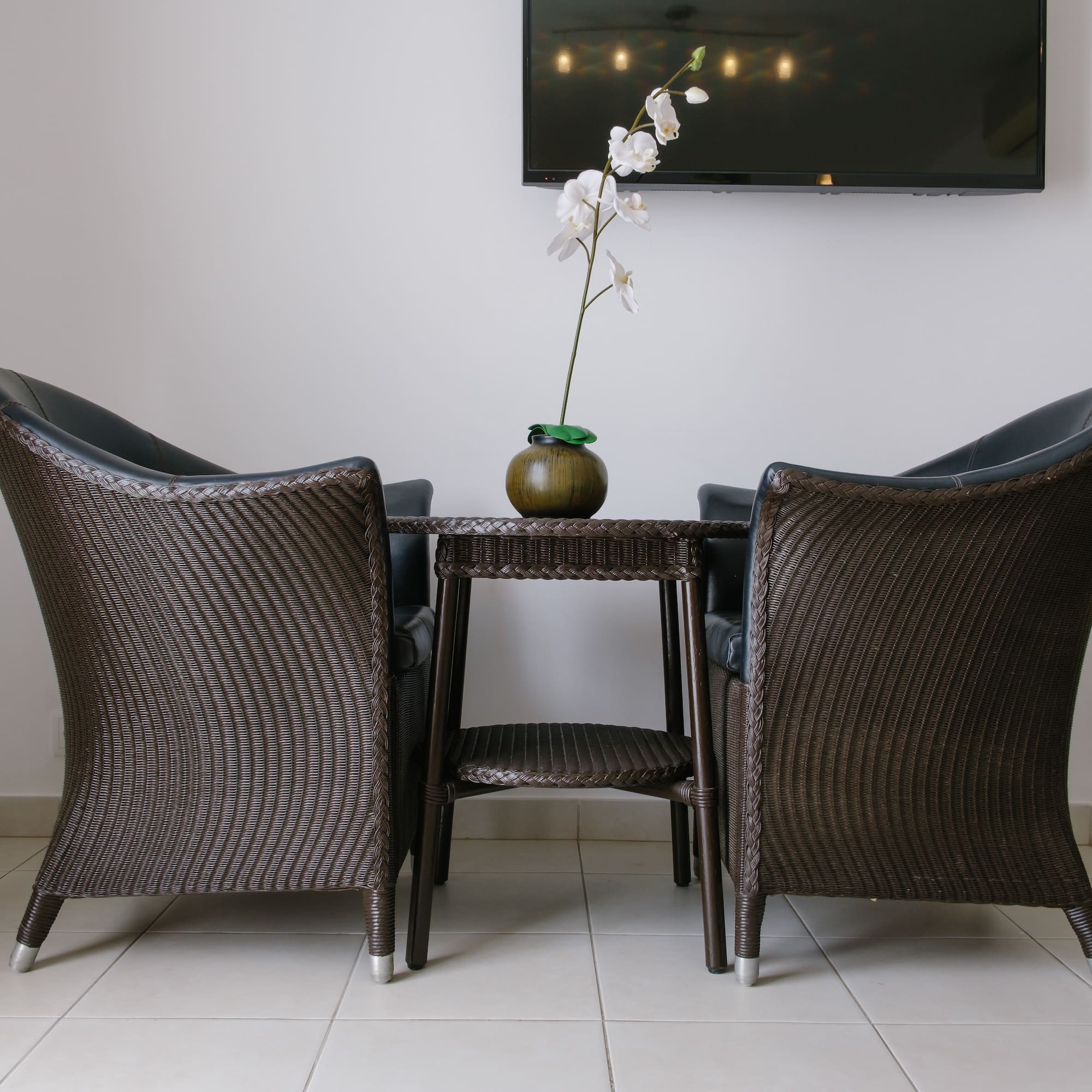 a table with chairs and a vase of flowers