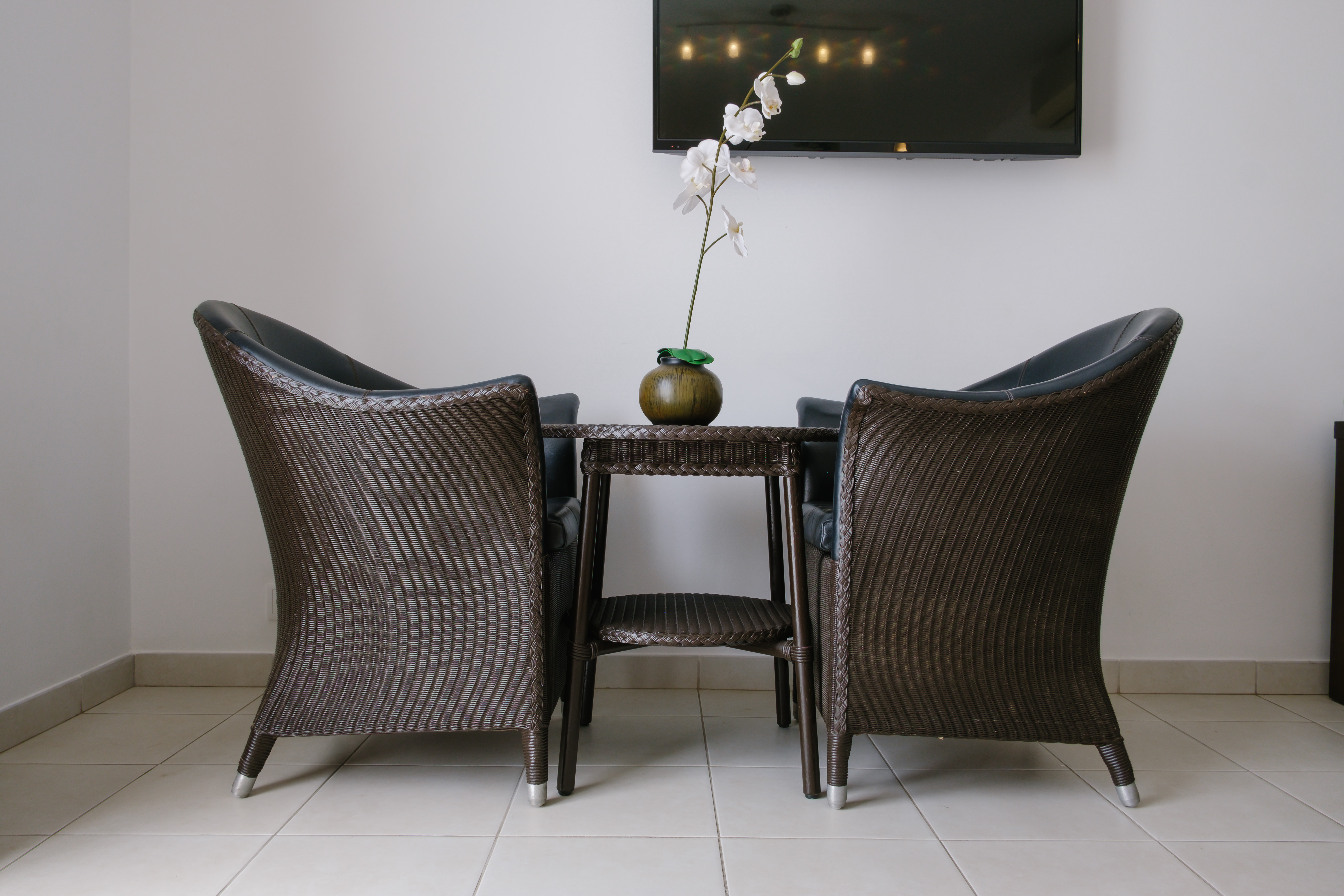 a table with chairs and a vase of flowers