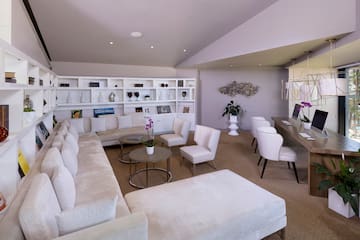 a room with white furniture and a table