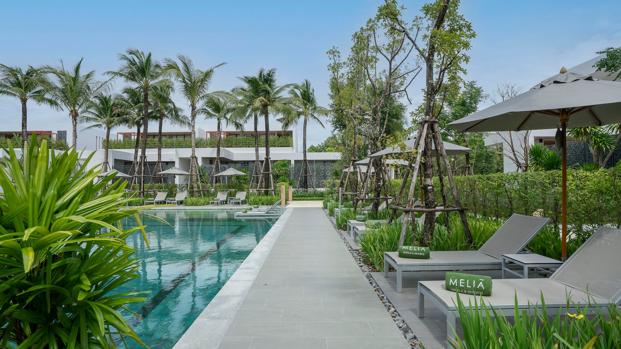a pool with lounge chairs and trees