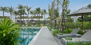 a pool with lounge chairs and trees