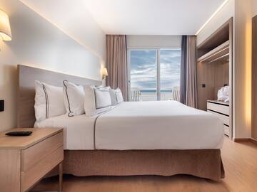 a bedroom with a large bed and a dresser