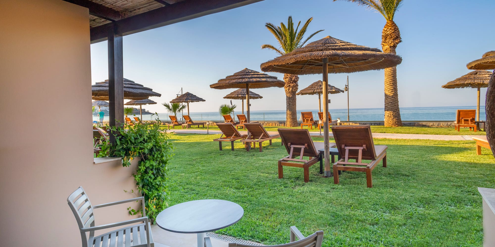a deck with chairs and umbrellas on the grass