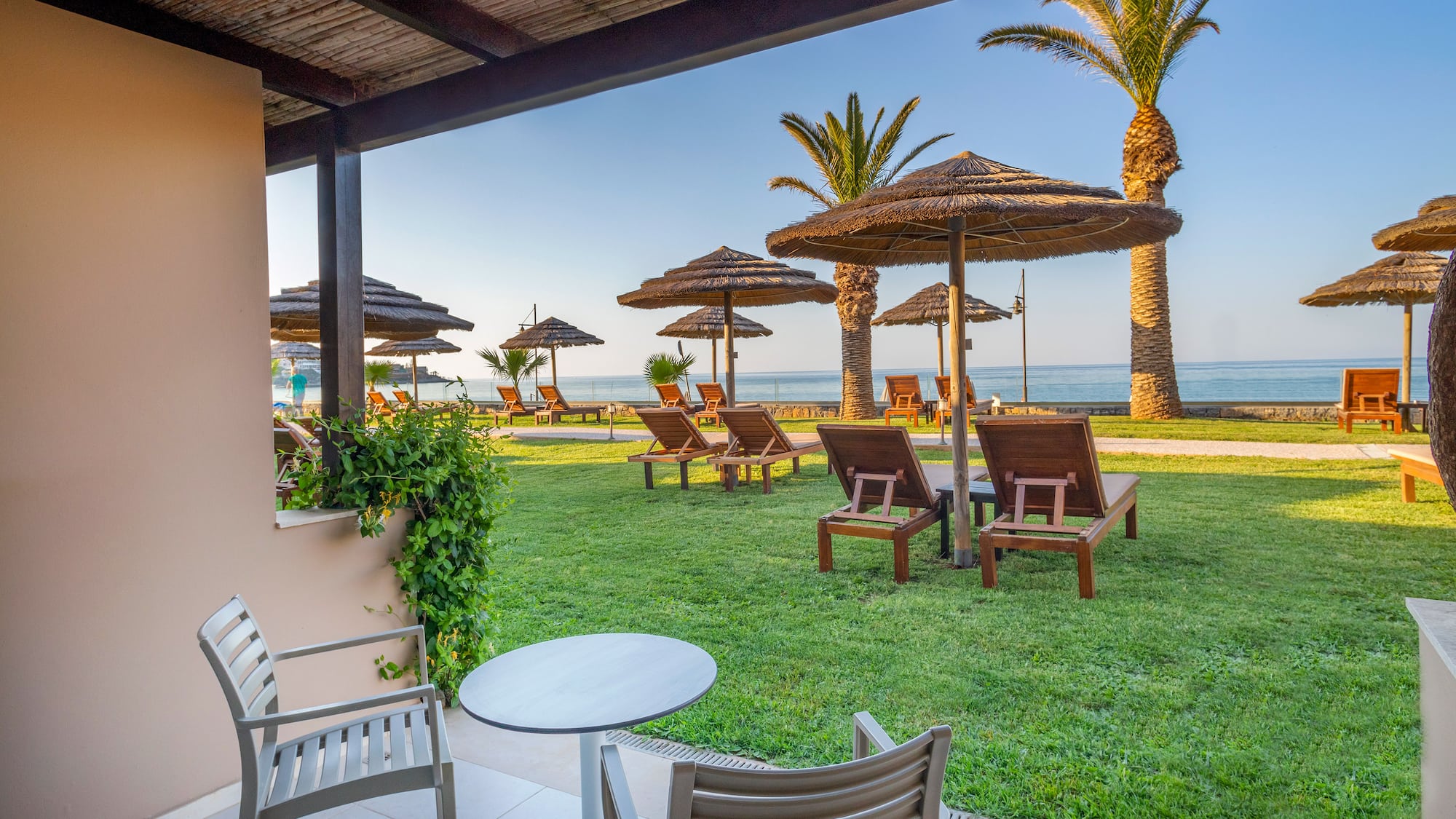 a deck with chairs and umbrellas on the grass