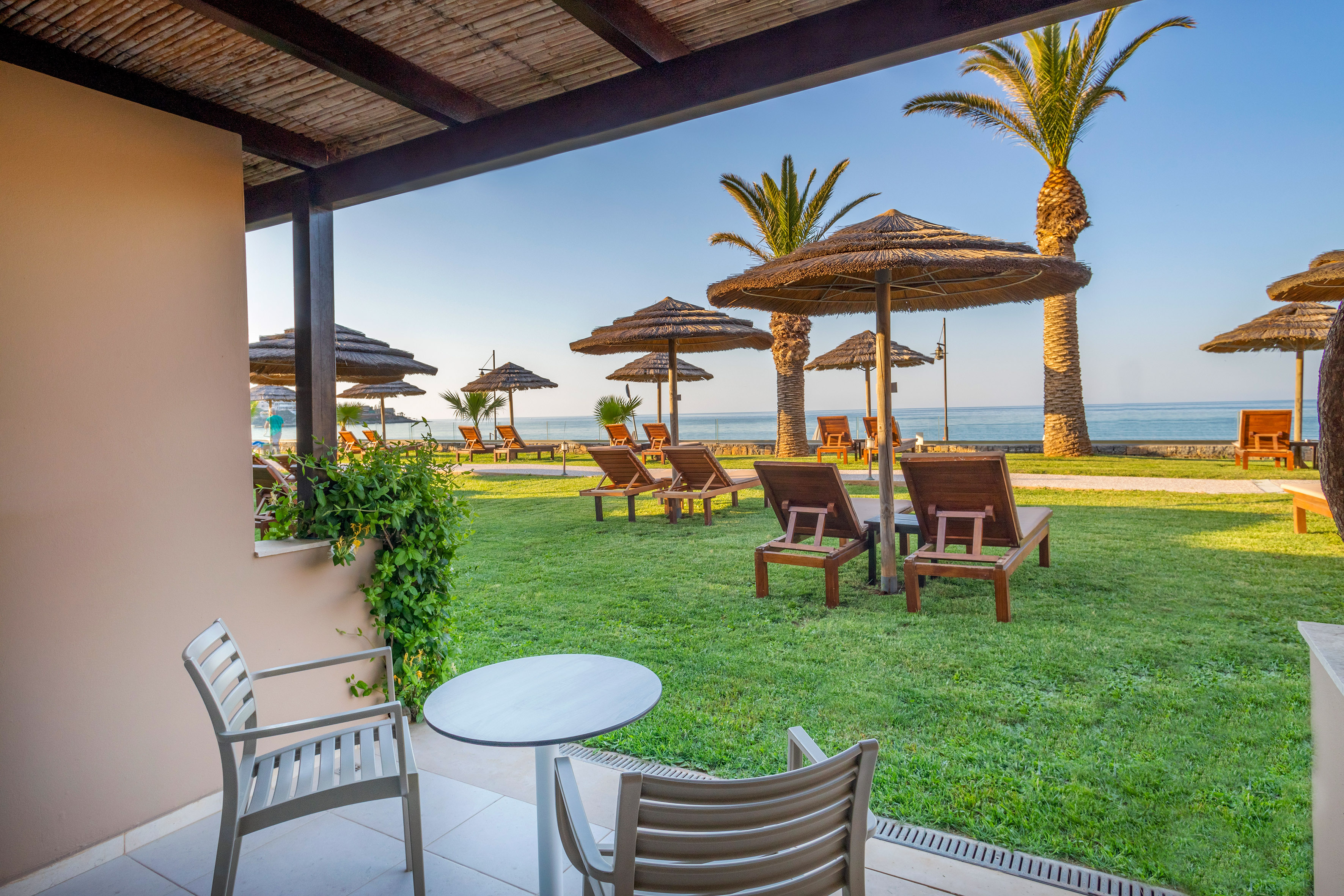 a deck with chairs and umbrellas on the grass