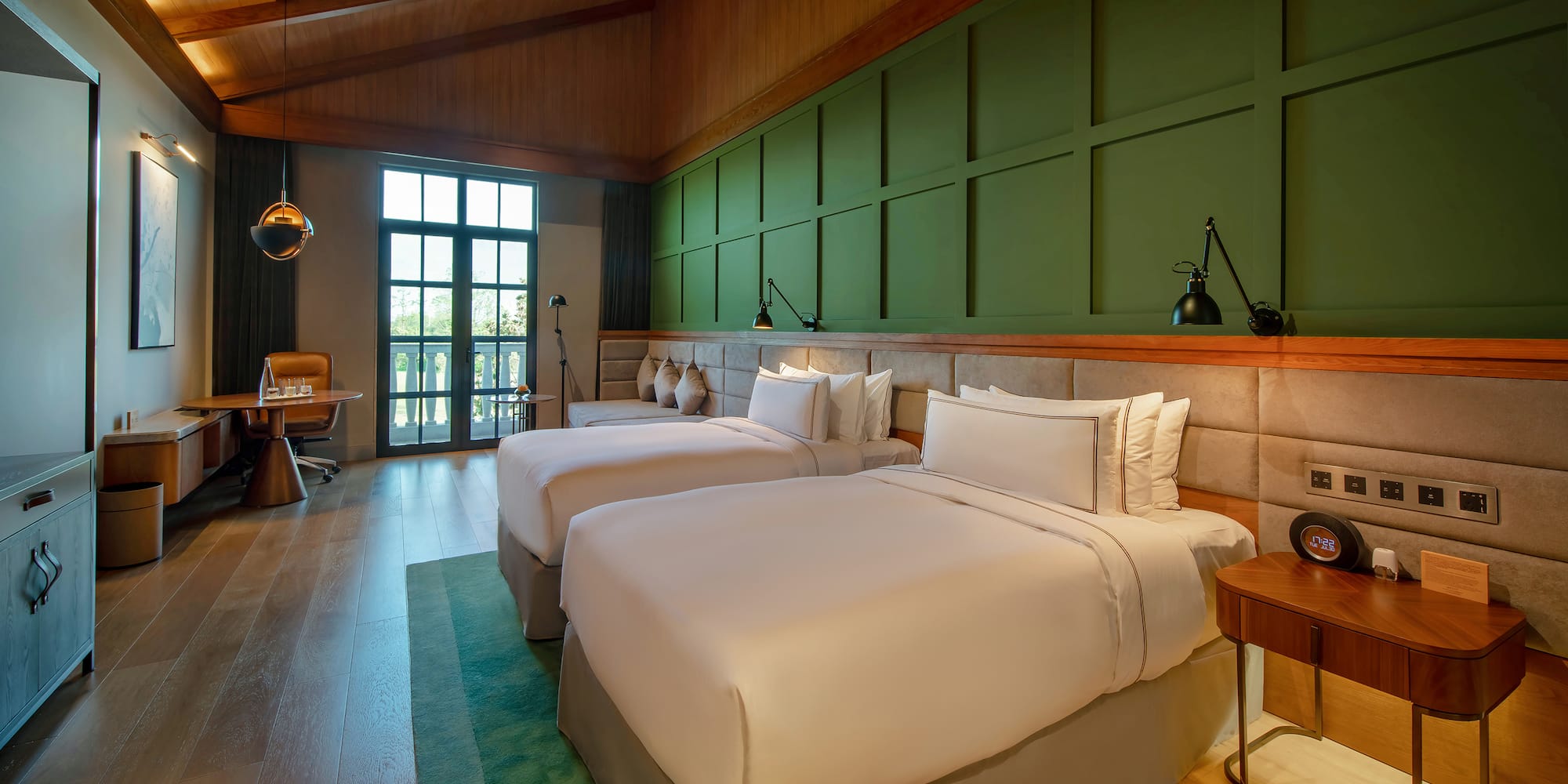 a room with two beds and a green wall