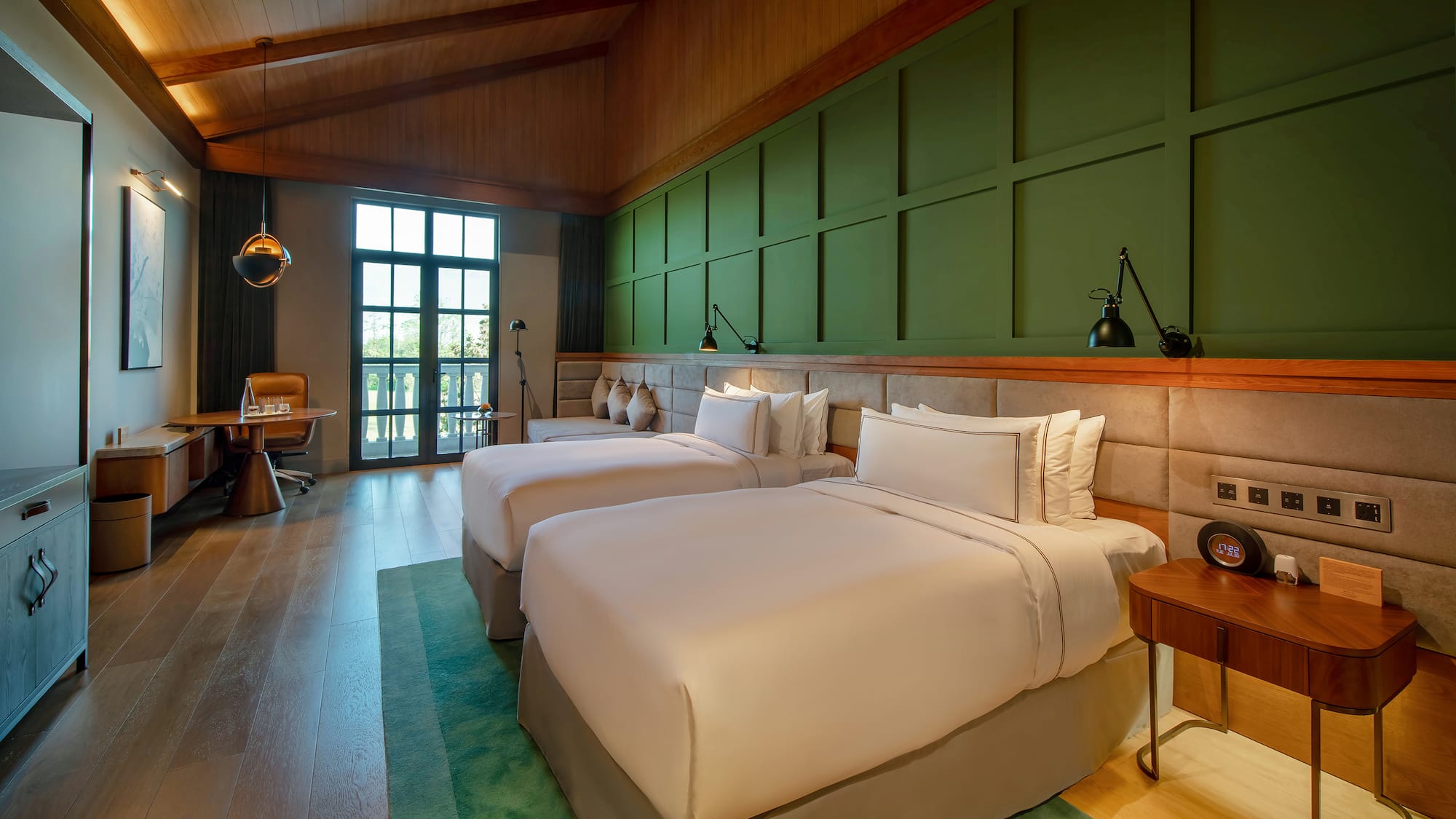 a room with two beds and a green wall