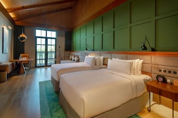 a room with two beds and a green wall
