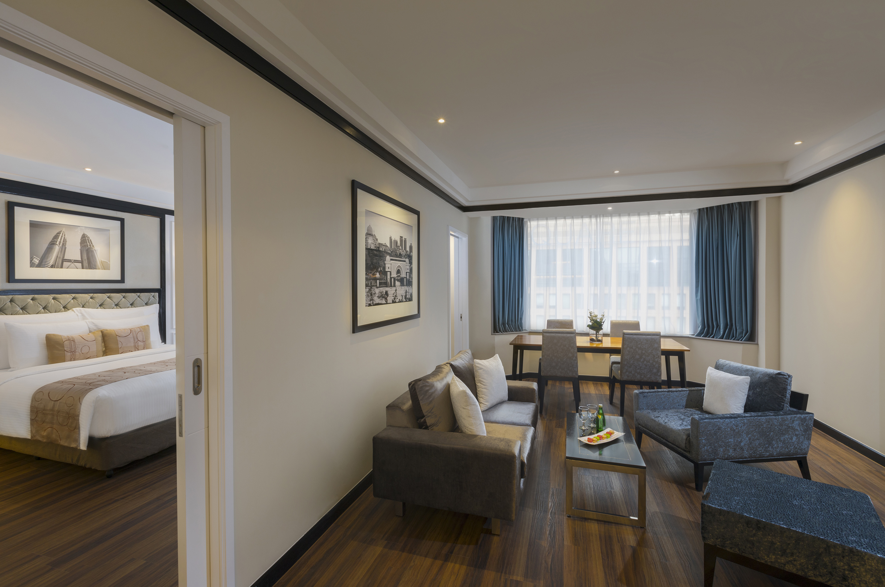 Modern hotel suite featuring living and dining areas, plus an open bedroom.