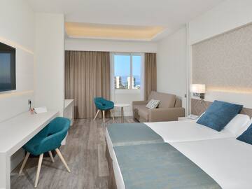 a room with two beds and a table and chairs