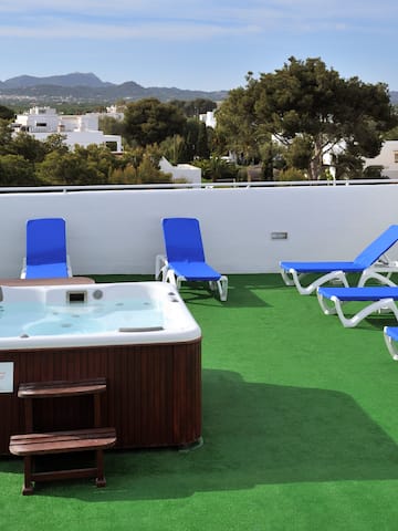 a hot tub and lounge chairs on a rooftop
