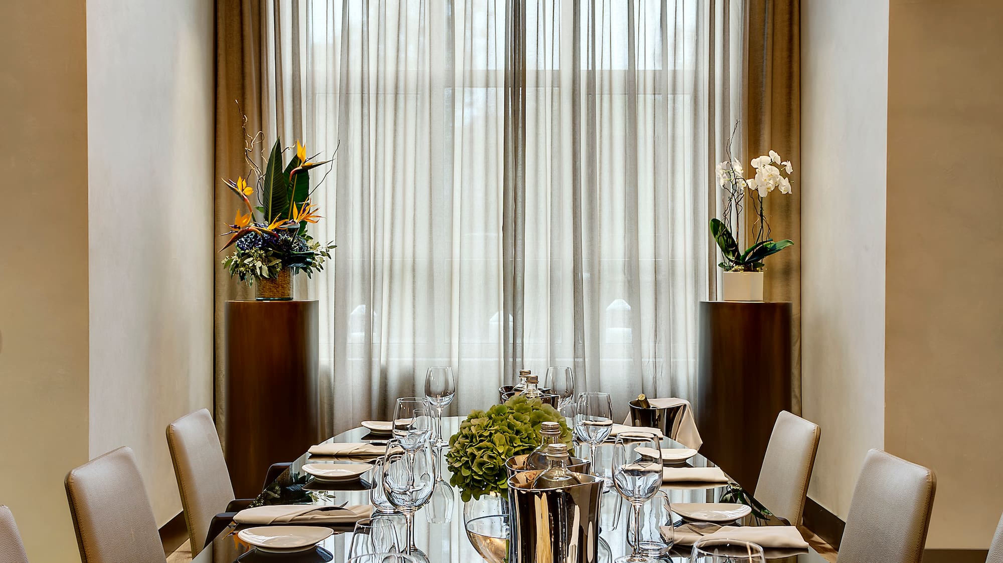 a long table with a chandelier and flowers