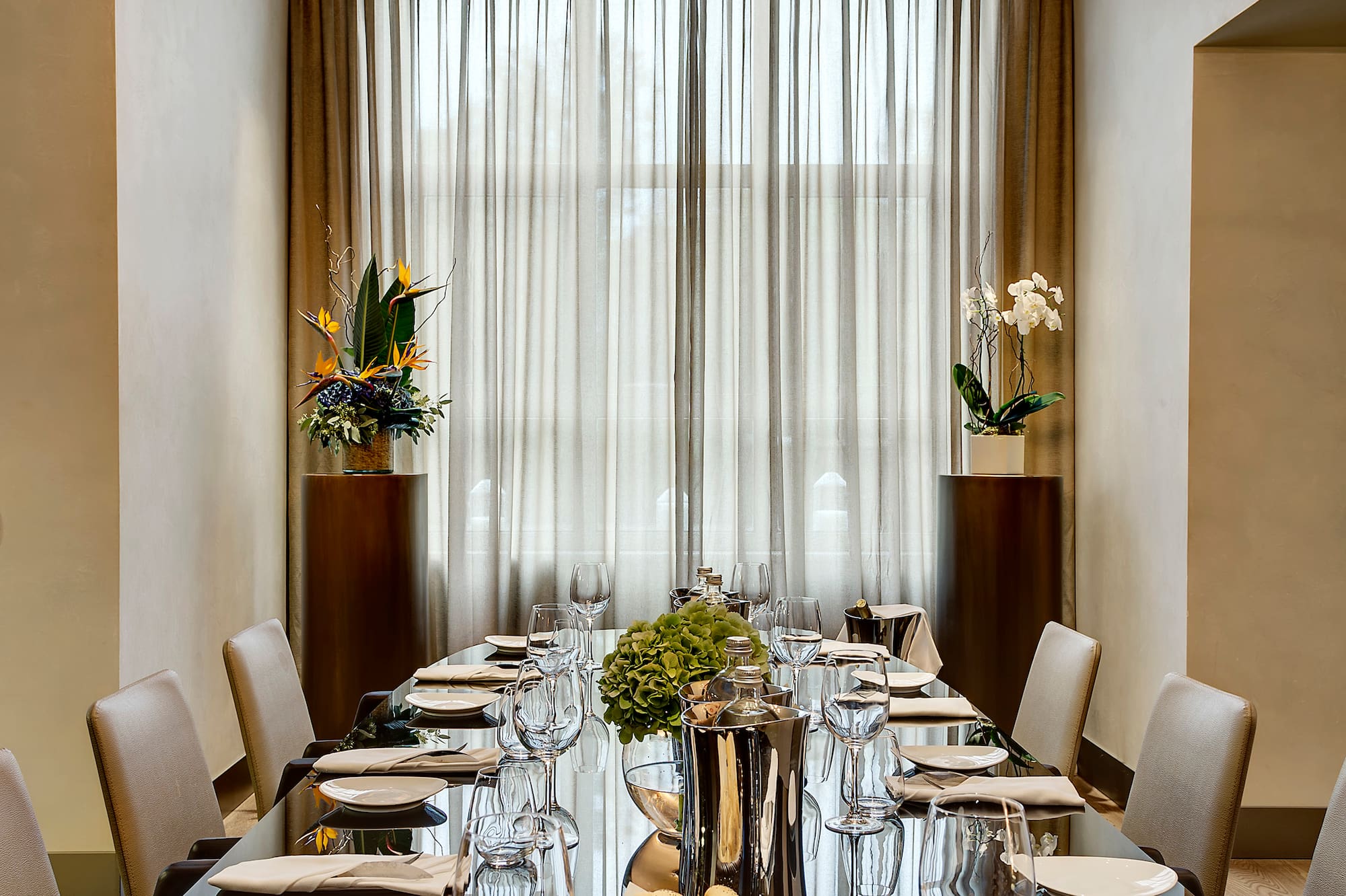 a long table with a chandelier and flowers