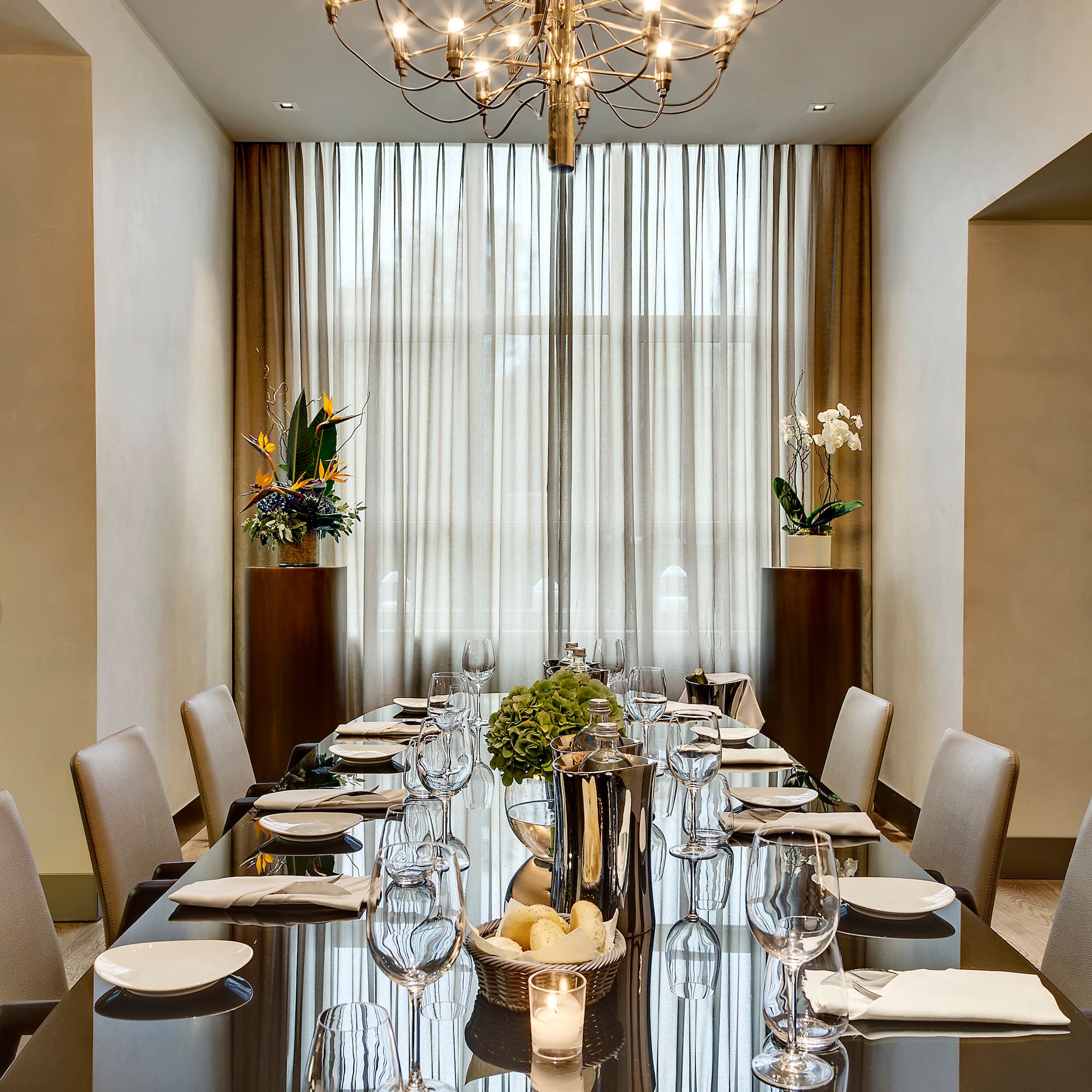 a long table with a chandelier and flowers