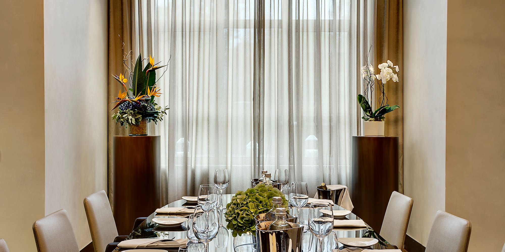 a long table with a chandelier and flowers