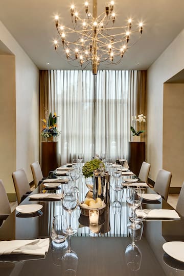 a long table with a chandelier and flowers