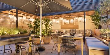 a patio with tables and chairs and umbrellas