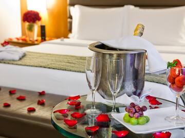 a champagne bottle in a bucket next to wine glasses and grapes