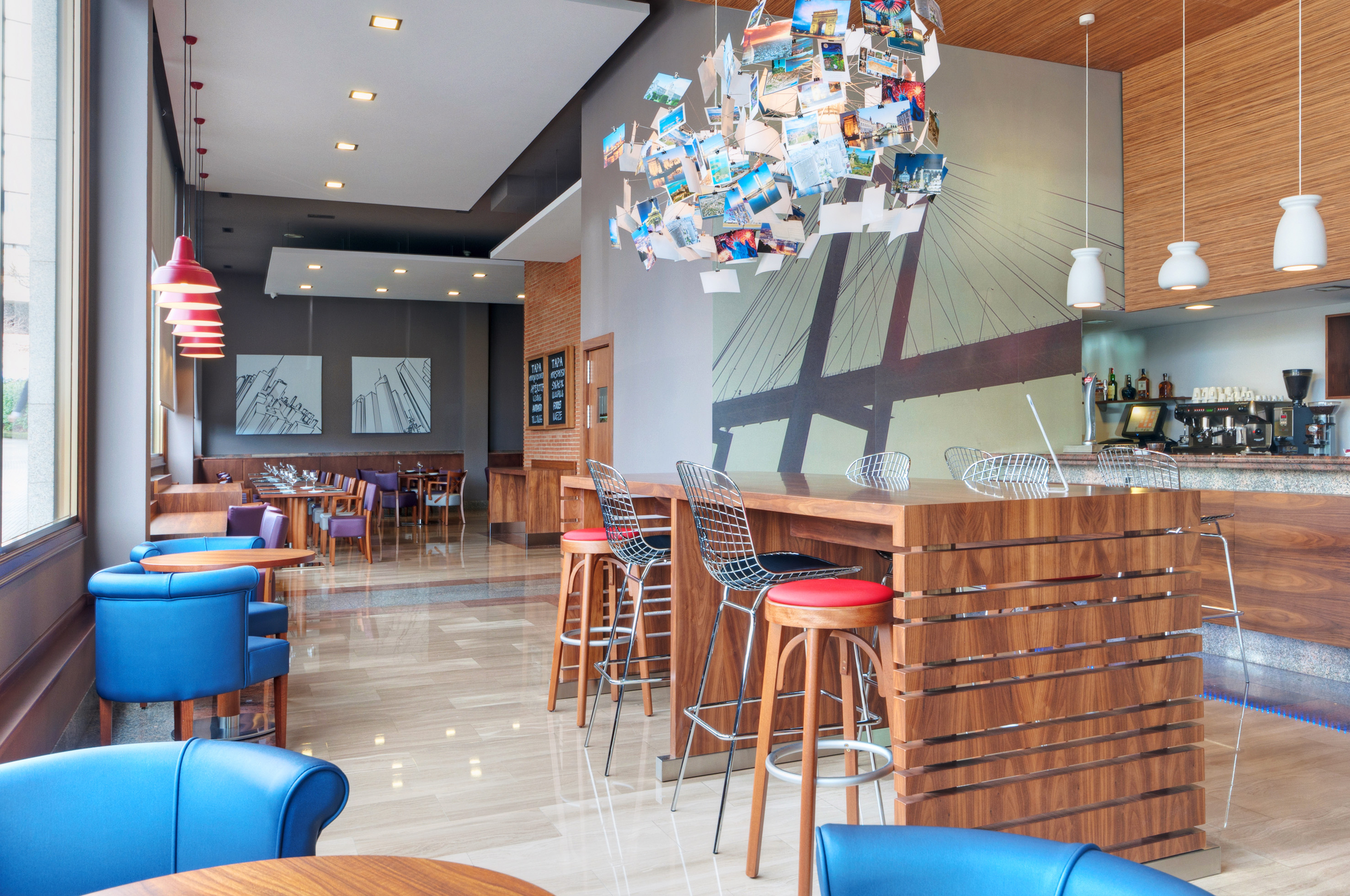 Modern restaurant interior with colorful seating and photo collage chandelier.
