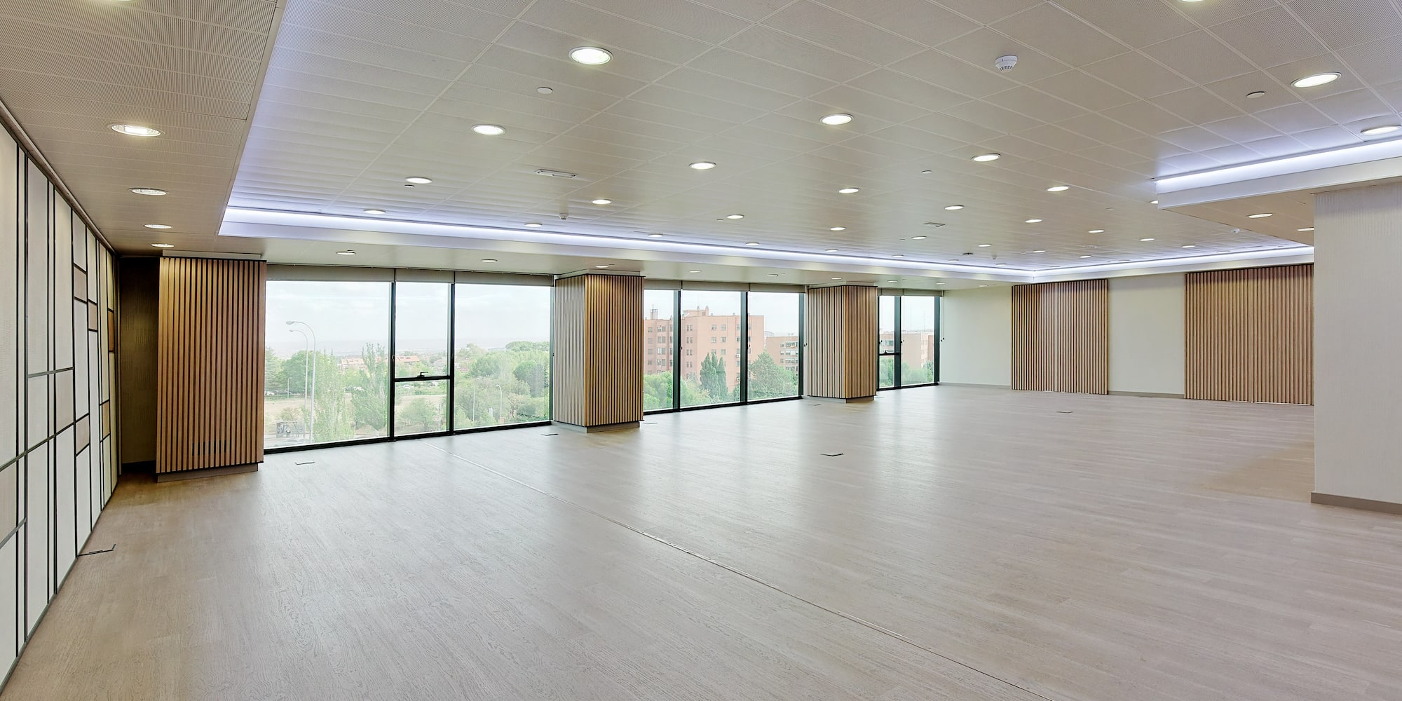 a large room with windows and a wood floor