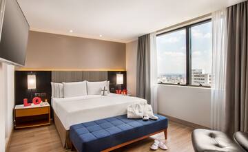 a bedroom with a bed and a blue ottoman