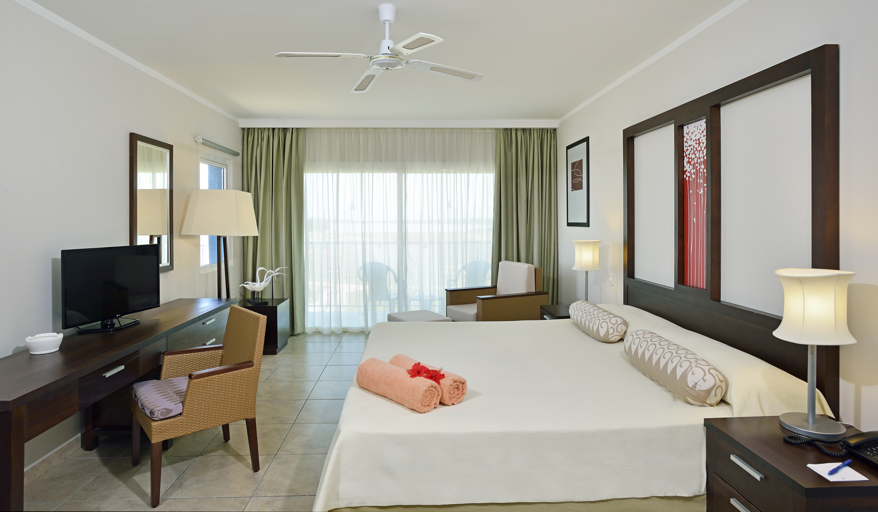 a room with a bed and a fan